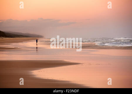 Lone fisherman, on Seventy Five Mile Beach, Fraser Island, Queensland, Australia. Fraser Island is the largest sand island in th