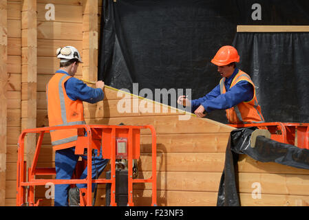 builders measure the wall of a lockwood style building Stock Photo