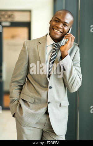 handsome African business man talking on mobile phone in office building Stock Photo
