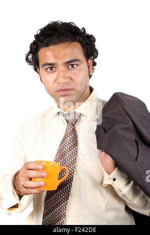 A young Indian businessman having a coffee during an office break. Stock Photo