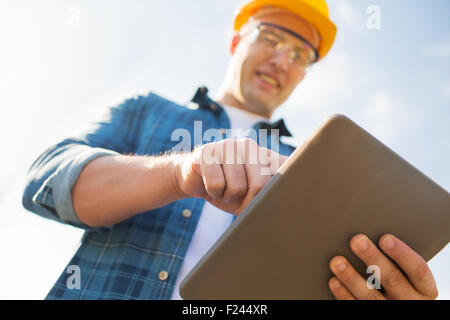 close up of builder in hardhat with tablet pc Stock Photo