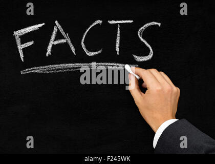 Man writing the word 'Facts' with chalk on blackboard background Stock Photo