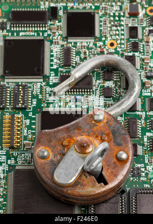 Old rusty open padlock on computer mainboard - information or data security concept Stock Photo