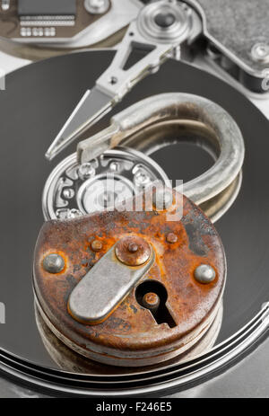 Old rusty open padlock on computer harddrive - information or data security concept Stock Photo
