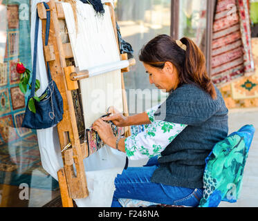 Side, Turkey - May 24, 2015: An unidentified woman working at the manufacture of carpets Stock Photo