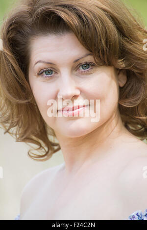 Portrait of a beautiful fashionable middle-aged woman in a bright pink