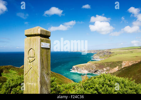 Coastal scenery on the South West Coast Path, East of Port Isaac, Cornwall, UK, with a path marker. Stock Photo