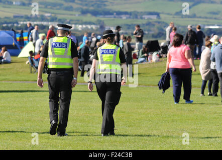 POLICE OFFICERS ON PATROL AT OUTDOOR EVENT FESTIVAL RE POLICING NUMBERS POLICEMEN OFFICER WALKING UNIFORM CUTS CRIMINAL  UK Stock Photo