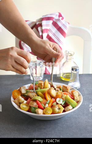 Women mixing ingredients for panzanella salad Stock Photo