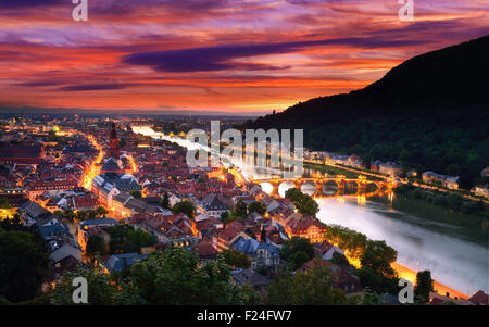Heidelberg, Germany, aerial view at dusk, with dramatic sunset sky and the lights of the city, Neckar river and the Old Bridge Stock Photo