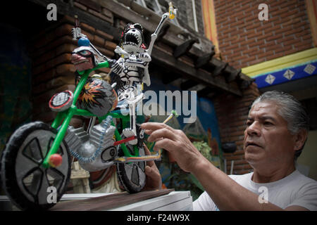 Mexico City. 4th Sep, 2015. Image taken on Sept. 4, 2015 shows Lino Garcia, son of Claudia Duran, checking a cardboard figure in a workshop in Mexico City, capital of Mexico. Lino Garcia, who was acquainted with the creation of cardboard figures when he was still a boy, works with his mother Claudia Duran, 80 years old, who has dedicated herself to creating artworks with cardboard since 31 years ago. © Alejandro Ayala/Xinhua/Alamy Live News Stock Photo