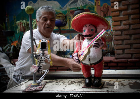 Mexico City. 4th Sep, 2015. Image taken on Sept. 4, 2015 shows Lino Garcia, son of Claudia Duran, placing a finished cardoard figure in a workshop in Mexico City, capital of Mexico. Lino Garcia, who was acquainted with the creation of cardboard figures when he was still a boy, works with his mother Claudia Duran, 80 years old, who has dedicated herself to creating artworks with cardboard since 31 years ago. © Alejandro Ayala/Xinhua/Alamy Live News Stock Photo