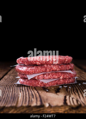 A raw Burger (minced Beef) on dark wooden background Stock Photo