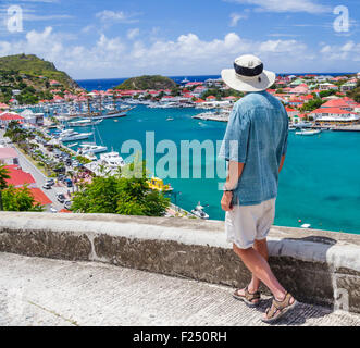 Tourist gazes at harbor at Gustavia on St. Barts Stock Photo