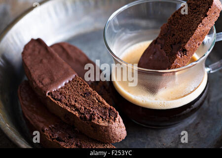 Chocolate biscotti cookies dipped in chocolate with a cup of coffee Stock Photo