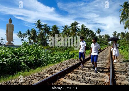 Sri Lanka, Southern Province, Galle district, Telwatta, school children walking on the railway from Colombo to Galle in front of the Peraliya Buddha in memory of the many victims of the crowded train swept away by the tsunami on December 26 2004 Stock Photo