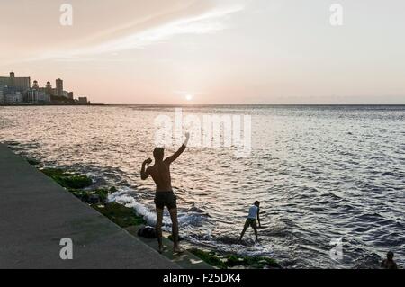 Cuba, Havana, fishermen and Vedado quarter buildings on Malecon Stock Photo