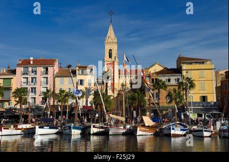 France, Var, Sanary-sur-Mer, traditional fishing boats called pointus in the port and St. Nazaire Church Stock Photo
