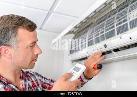 Man checking air conditioning unit Stock Photo