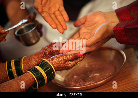 The hands of bride and groom being washed with holy water in a traditional Hindu wedding ritual Stock Photo