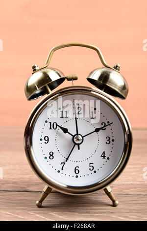Retro classic wooden alarm clock on desk vintage color background with ...