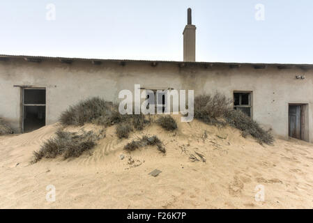 The abandoned ghost diamond town of Kolmanskop in Namibia, which is slowly being swallowed by the desert. Stock Photo