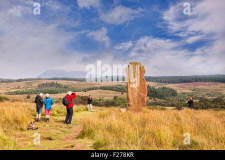 Tourists taking photos of one of the standing stones on Machrie Moor, Arran, North Ayrshire, Scotland. Stock Photo