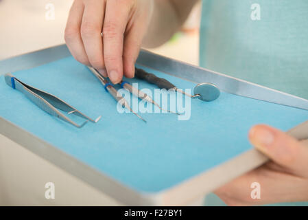 Dental assistant holding tray of dental instruments at the dental clinic, Munich, Bavaria, Germany Stock Photo