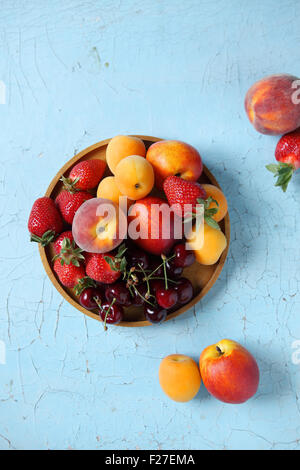 Summer berries cherry apricots on dark surface food background Stock