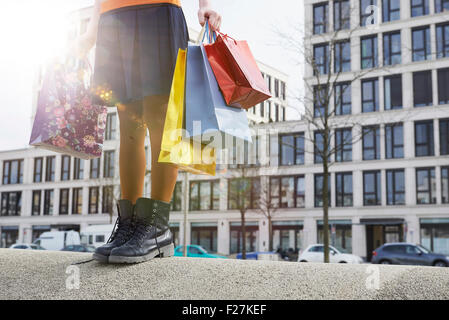 Low section view of woman holding shopping bags, Munich, Bavaria, Germany Stock Photo