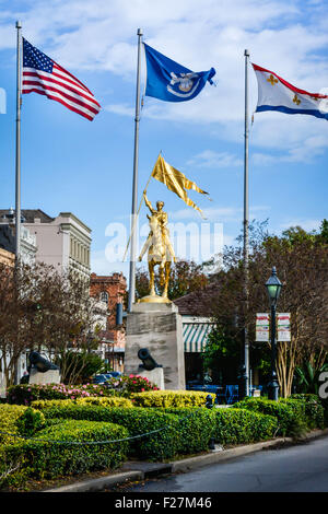 Flags fly high around the gilded bronze Equestrian Statue of Joan of Arc, located in the French Quarter, New Orleans, LA Stock Photo