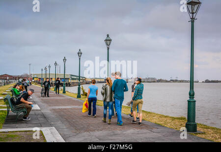 People strolling the riverfront park area overlooking the Mississippi River, near Jackson Square in New Orleans, LA Stock Photo