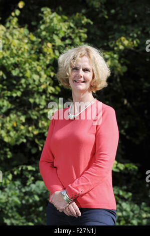 Mature middle aged woman wearing coral pink coloured top and blue trousers Stock Photo
