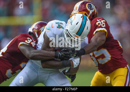 Miami Dolphins quarterback Jacoby Brissett (14) tries to hold off an attack  by Buffalo Bills defensive tackle Justin Zimmer (61) during the second half  of an NFL football game, Sunday, Sept. 19