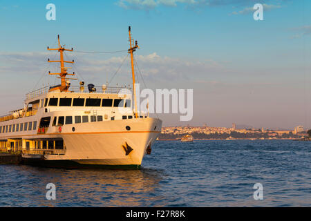 Passenger ship parked on Karakoy pier golden hour times near Golden Horn in Istanbul Stock Photo
