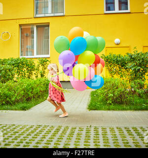 happy little girl outdoors with balloons Stock Photo