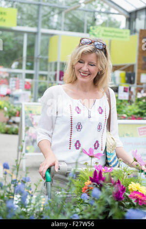 Mature woman shopping in garden centre, Augsburg, Bavaria, Germany Stock Photo