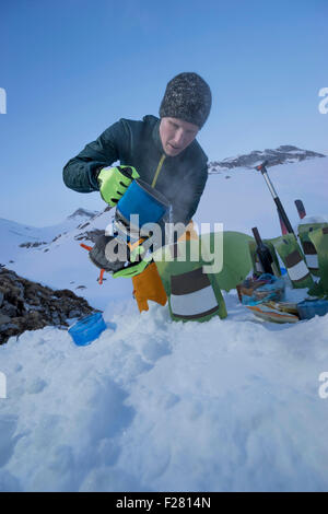 Man preparing ready meals to the bivouac camp, Tyrol, Austria Stock Photo
