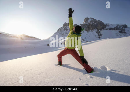 Man doing yoga on snowcapped mountain during sunrise, Tyrol, Austria Stock Photo