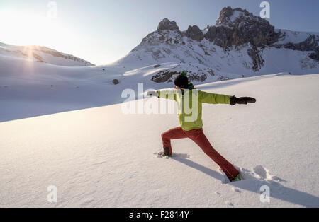 Man doing yoga on snowcapped mountain during sunrise, Tyrol, Austria Stock Photo