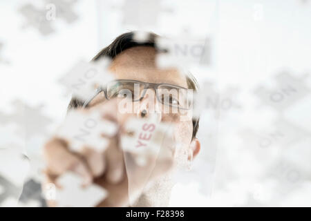 businessman arranging jigsaw puzzle pieces, Bavaria, Germany Stock Photo