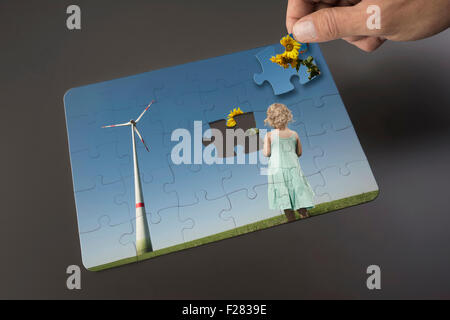 Hand placing last piece into jigsaw puzzle, Bavaria, Germany