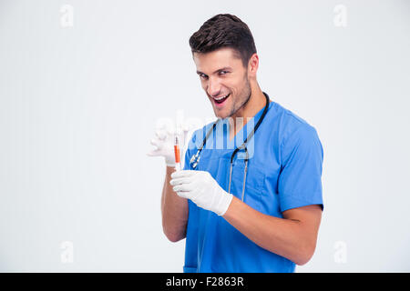 Portrait of a funny male doctor holding syringe isolated on a white background Stock Photo