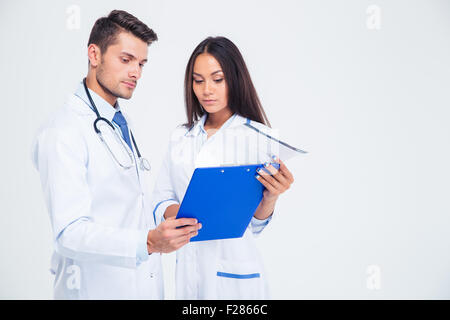 Portrait of a two medical workers looking at clipboard isolated on a white background Stock Photo