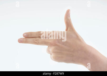 Hand Making Gun Sign Woman's hand showing pistol symbol over light background Stock Photo ...