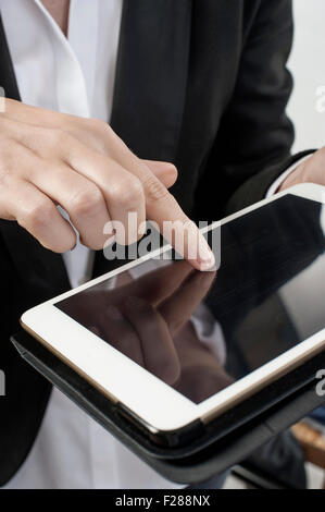 Midsection view of businesswoman operating digital tablet in office, Bavaria, Germany Stock Photo