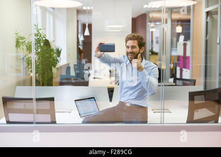Selfie casual businessman taking pictures in open space office Stock Photo