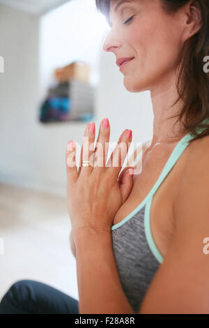 Side view of woman practicing yoga sitting in prayer position. Woman meditating in yoga pose.