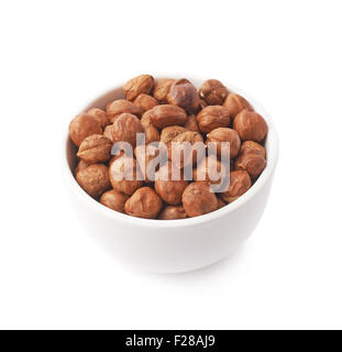 White ceramic cup bowl filled with the multiple hazelnuts isolated over the white background Stock Photo
