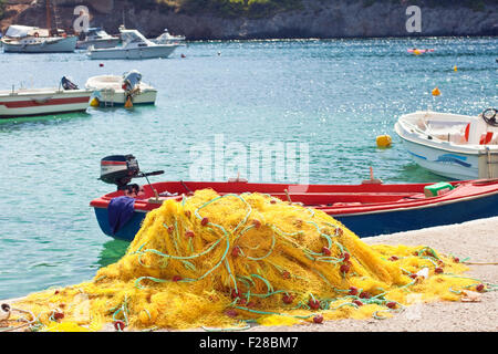 Yellow nylon fishing net with float line attached to small red plastic  floats Stock Photo - Alamy